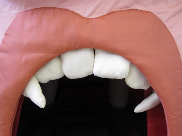 Fabric sculpture of a mouth with prominent canines