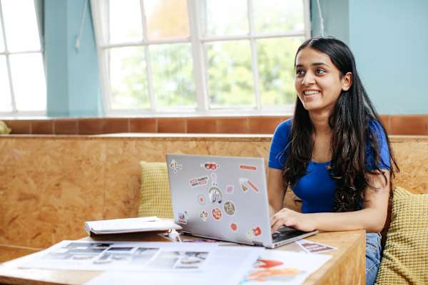 Pre-degree student Vishala Choulan working on her laptop in the canteen at Lime Grove