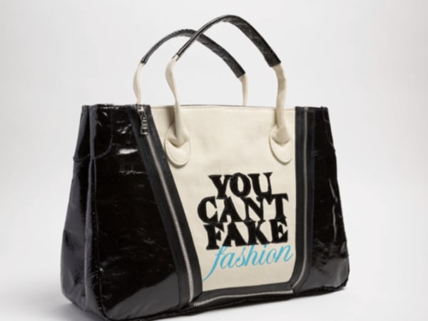 Handbag with text, 'You Can't Fake Fashion' written on it.