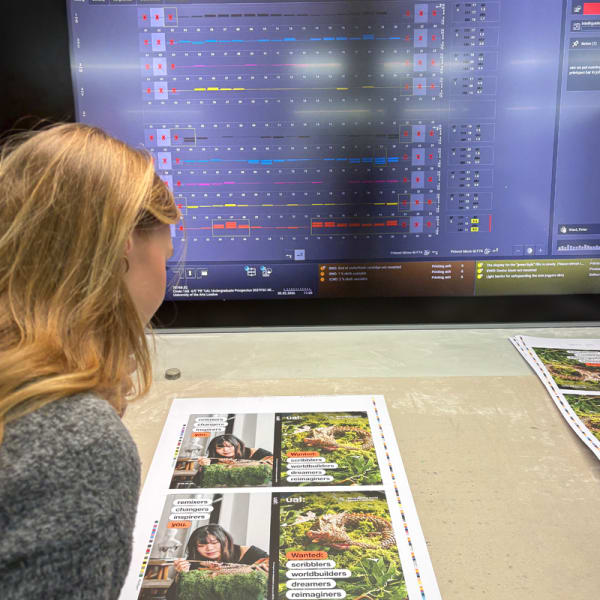 Person reviewing printed proof of UAL Postgraduate Guide cover