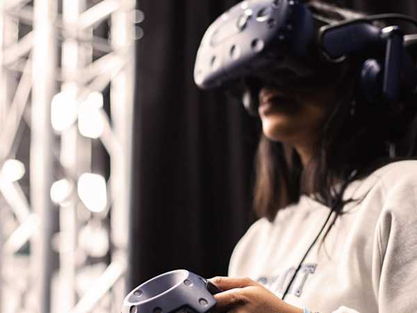 Student using a virtual reality headset and handheld controller.