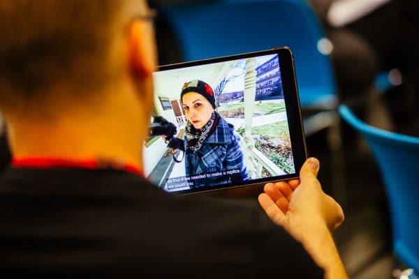 Image of woman holding videocamera viewed on an ipad