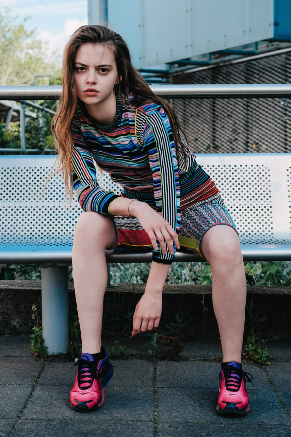 Model wearing garment made of colourful stripey knitted textiles by Priscilla Luong.