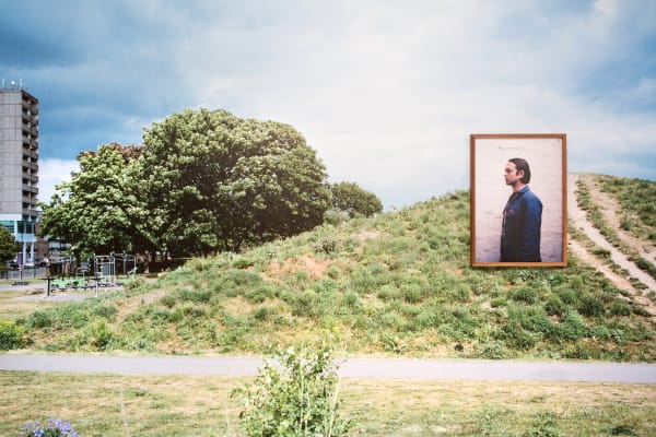 Green space with a large photography installation of a man.   