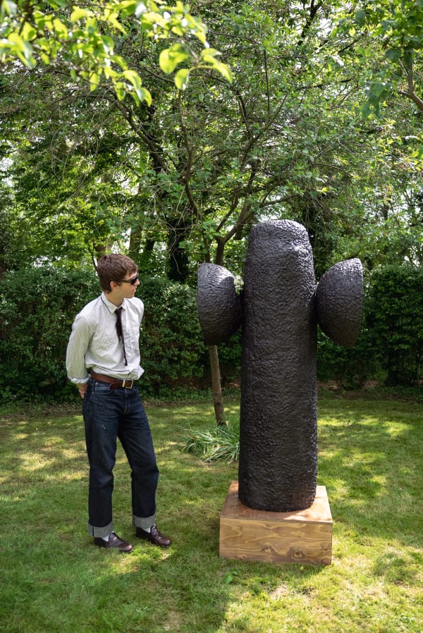 student standing next to their sculpture