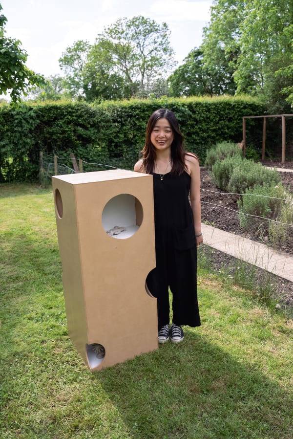student standing next to their sculpture