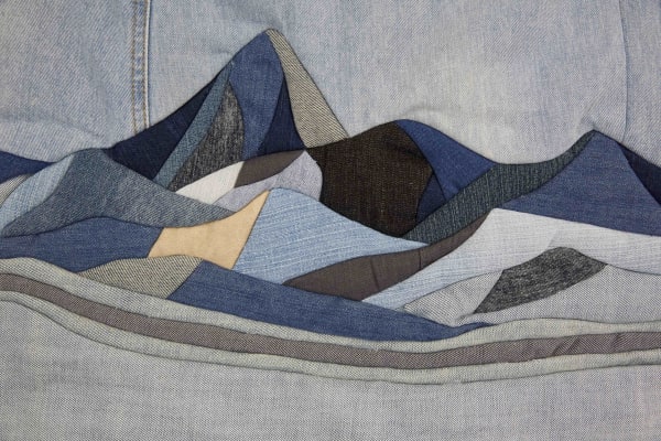 A blue landscape of hills made from denim fabrics