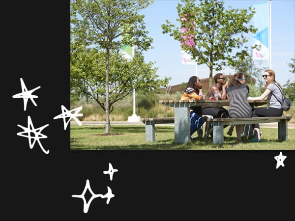 Summer at the Queen Elizabeth Olympic Park, people sat at a bench on the Park. Photography by London Legacy Development Corporation.