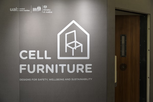 A grey panel with a cell shaped logo and text Prison Cell Furniture
