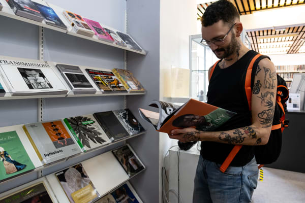 Student in WCA library looking at a display of books 
