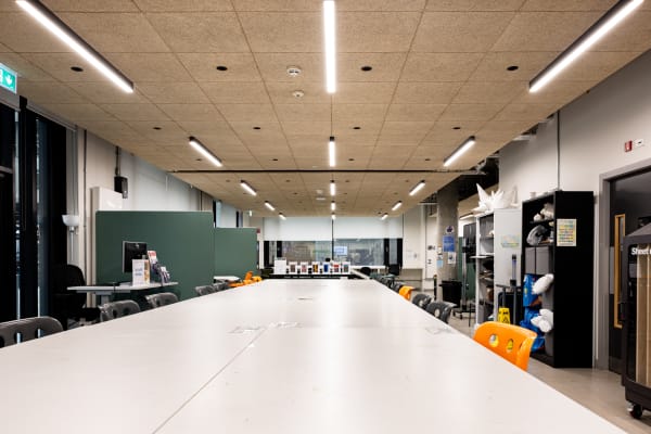 View of large workshop and study room featuring room dividers creating private  workstations and pattern cutting table..