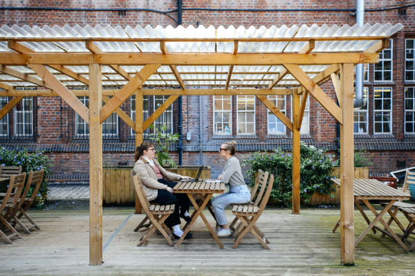 Two people sitting in the Courtyard at Archwood House