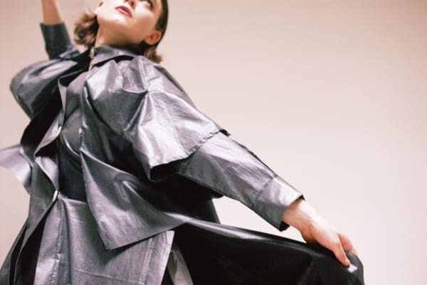 Woman swirling in a silver trench coat