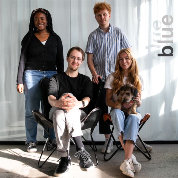 Four people pose for a corporate photograph, 2 are stood behind and two are sat in front.