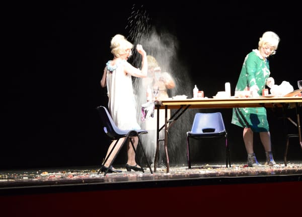 3 women dressed as Dusty Springfield having a food fight performance.