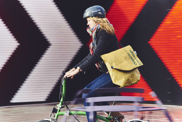 Woman riding a bicycle with an anti-theft bag