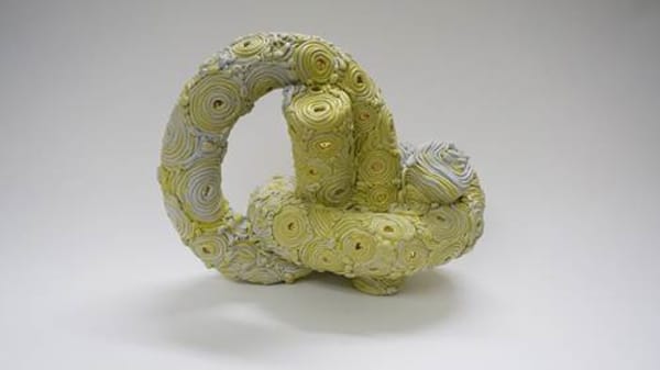 Yellow spiral sculpture, made using pool noodles, sequins and pins