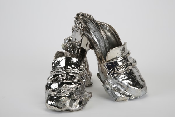 A pair of shoes cast in a silver coloured metal