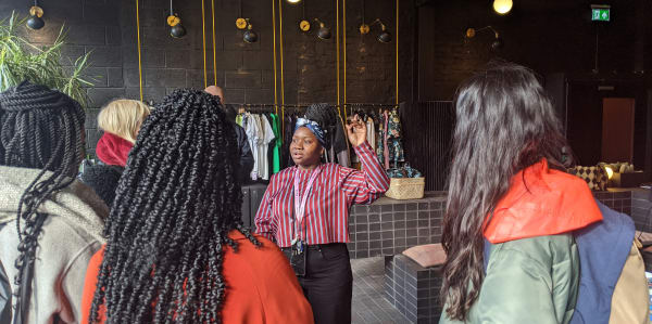 Someone giving a tour to students visiting clothing shop