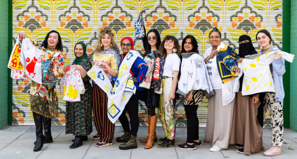 Women displaying their colourful, sustainable materials as part of a community project.