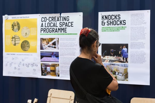 A person looking at wall boards with information about social and community projects.