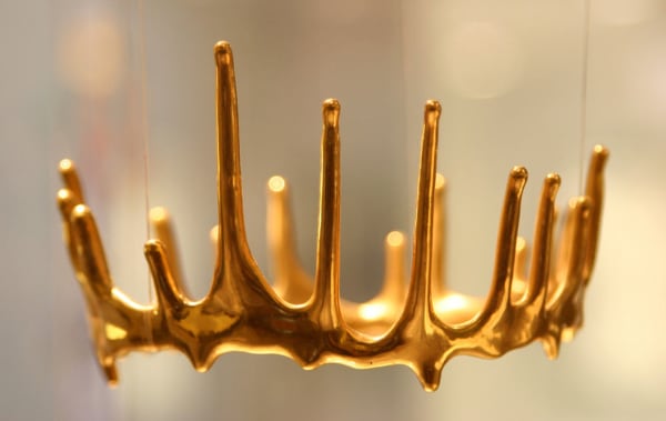Gold crown shaped sculpture suspended in the air