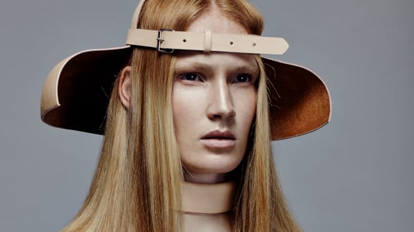Female model in hat with glossy strawberry blonde hair.