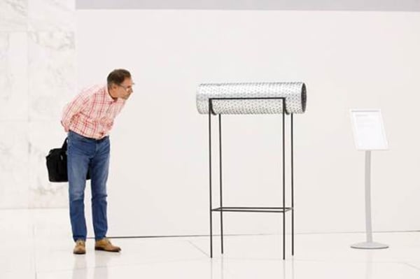 Man looking at sculpture in a gallery