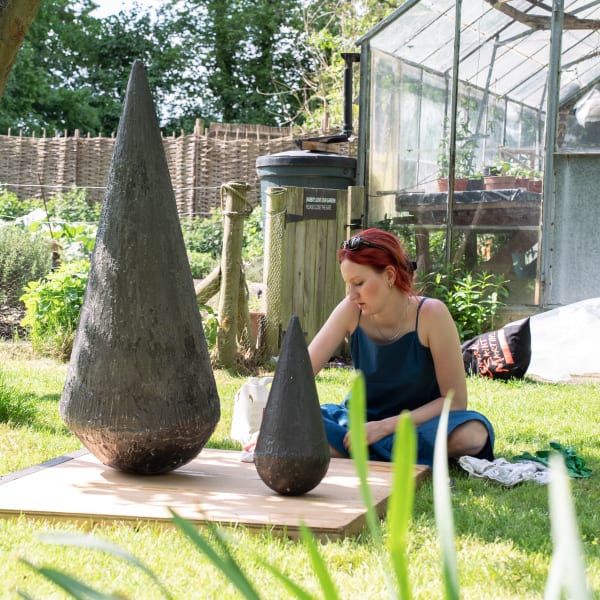 student standing next to their sculpture