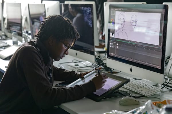 A student using a touchpad to draw illustrations for animation