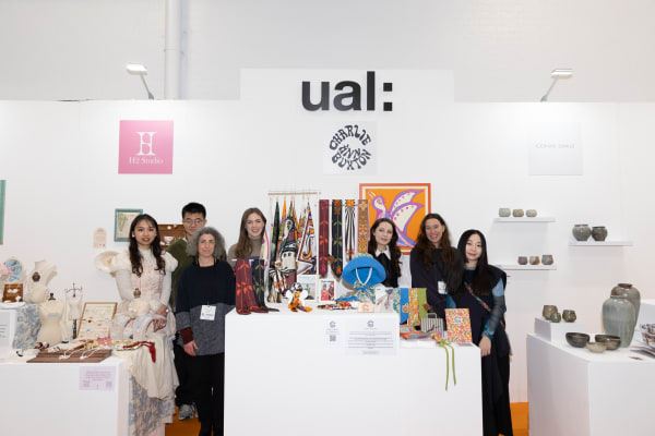 A group of people pose for the camera at Top Drawer design trade show in front of the UAL stand
