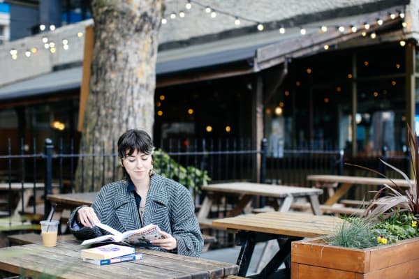 Student reading in outside seating area