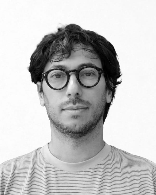 A black and white portrait shot against background greenery