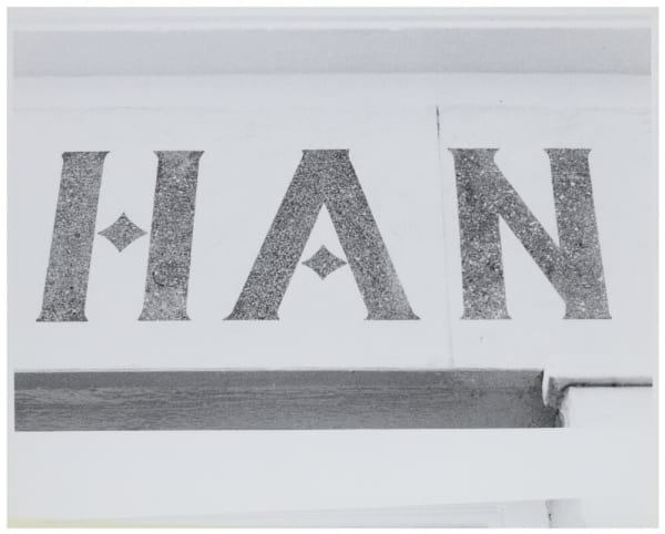 Black and white photograph of a section of a shopsign, with the letters ‘H.A.N.’