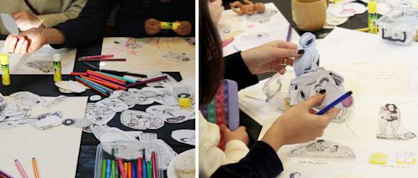 Drawings and collage pieces on tables being worked on in a workshop setting
