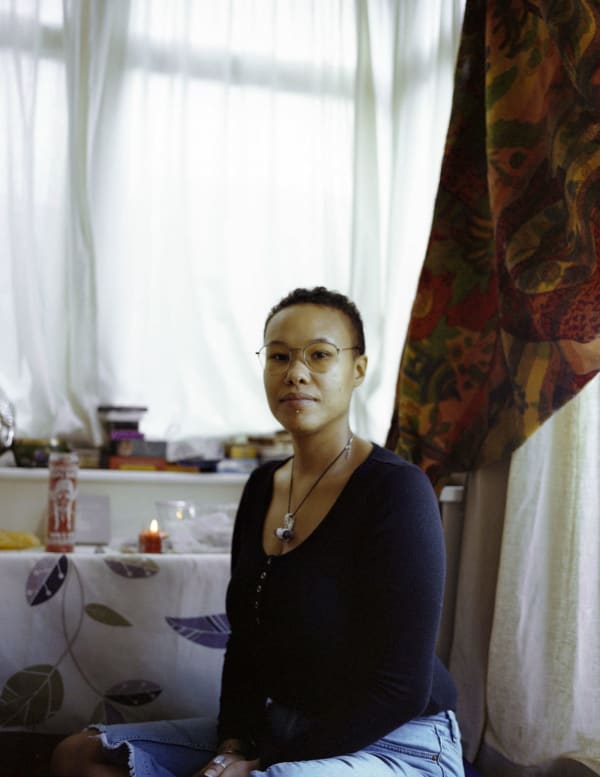 Portrait of a black woman called 'Corinna' taken in her home by Harriet Moore.