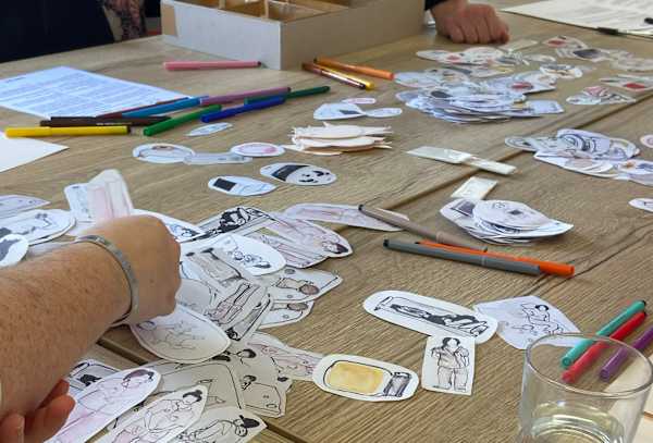 Paper and card-based materials laid on a table in a workshop scenario