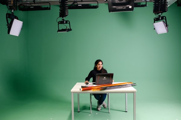 student in the green screen studio