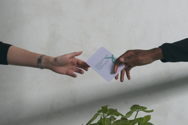 Two hands exchanging a piece of paper
