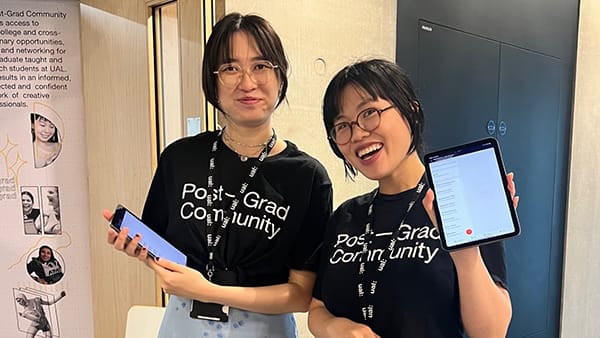 two students with postgrad community tshirts smiling