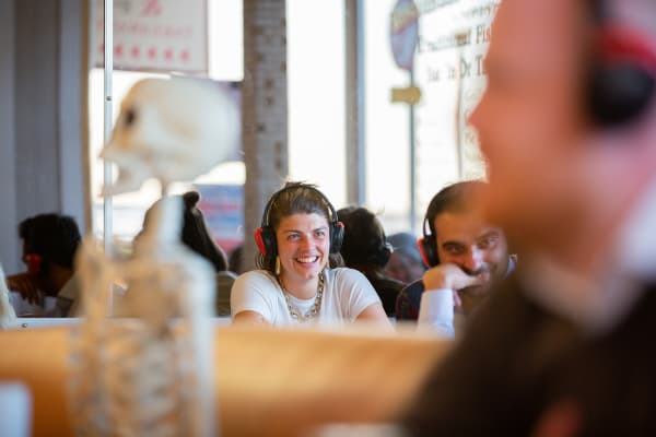 Girl in cafe with headphones on smiling.