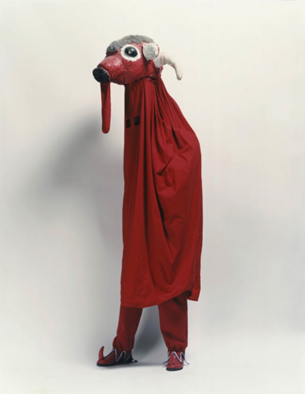 model in red character costume with mask, in a studio.