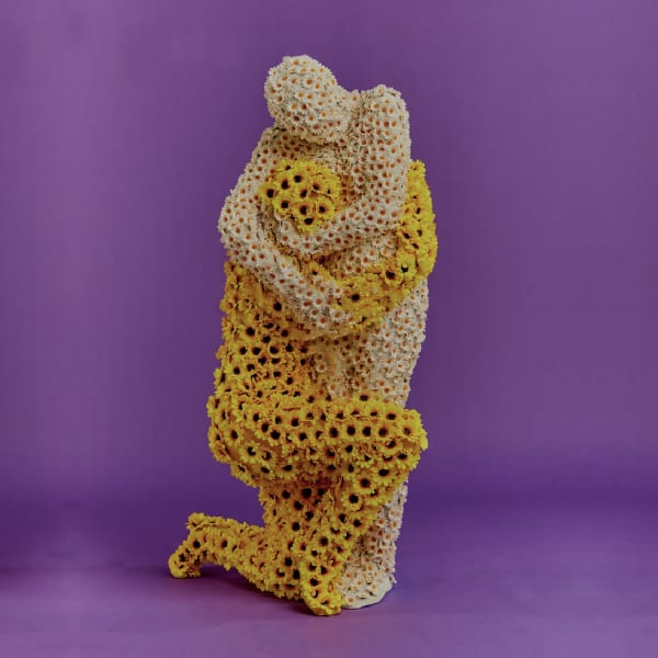 two people covered in flowers hugging against a purple backdrop