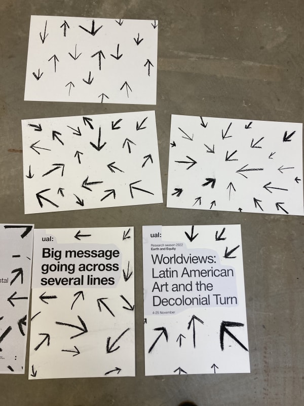 Paper laid on the floor with charcoal arrow drawings