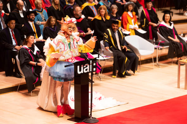 UAL Chancellor Grayson Perry wearing his graduation robe on stage