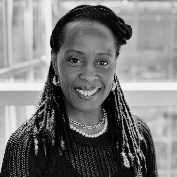 Michelle Philgence, a woman with dark hair in dreadlocks, wearing a knitted jumper, smiling at the camera