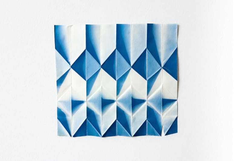 A5 folded paper with blue geometric triangular pattern