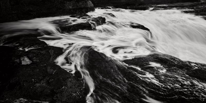 Black and White images of the sea surging towards high tide