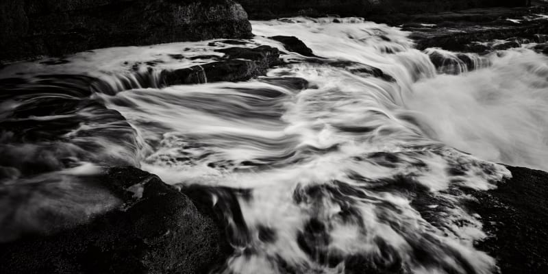Black and White photographs of the sea surging towards high tide