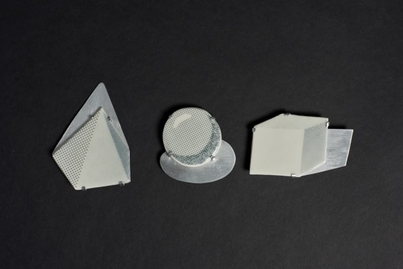 ceramic cube, sphere, and triangular pyramid in each silver shadow. They looks like 3D but they are 2D.